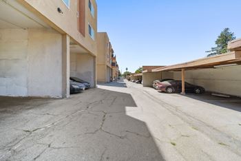 A parking lot with cars parked under awnings.